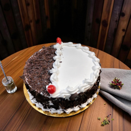 Twin Glory Black Forest Cake with half chocolate shavings and half white cream, topped with cherries.