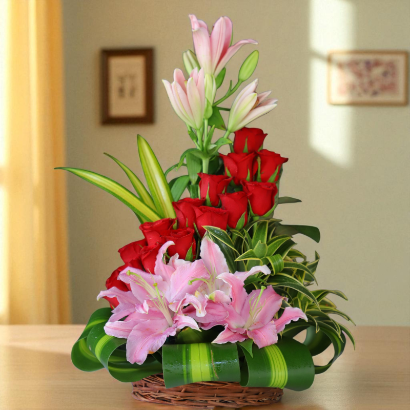 Red roses and pink lilies basket arrangement with decorative greens