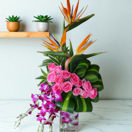 Exotic Flower Vase Arrangement – Pink roses, orchids & Bird of Paradise in designer vase with tropical leaves.