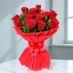 12 red rose hand bouquet wrapped in red paper with ribbon bow
