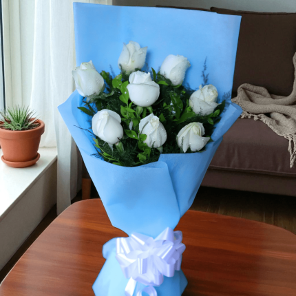 fresh white roses wrapped in sky blue paper with white ribbon