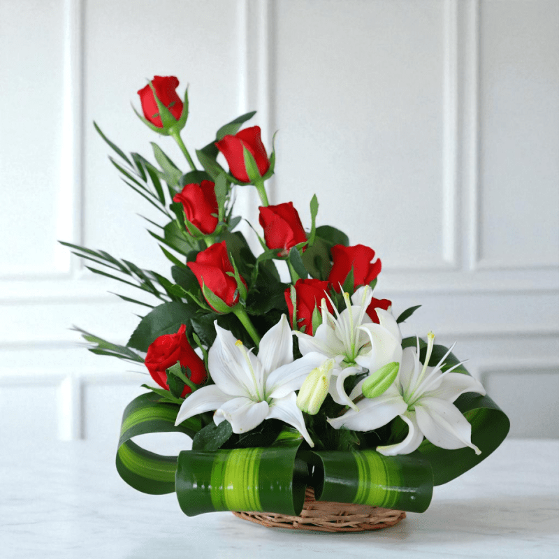 red roses and serene white lilies, beautifully hand-arranged in a charming cane basket - YHOJA.COM