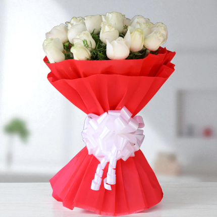 20 White Roses wrapped in bold red designer paper with a white bow – elegant floral gift.