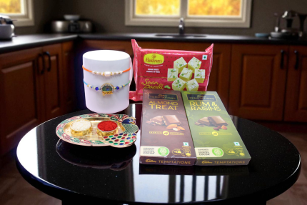 a Krishna Rakhi, a graceful Pearl Rakhi, two premium Cadbury Temptations chocolate bars & Soan Papdi - YHOJA.COM
