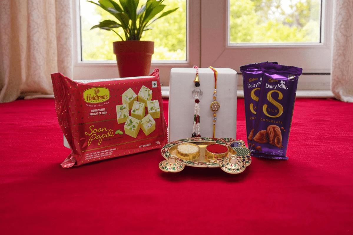 this Festive Bhaiya Bhabhi Rakhi Hamper with Soan Papdi Or Dairy Milk Silk Chocolate