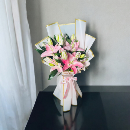 Pink oriental lily bouquet wrapped in premium white paper with ribbon bow