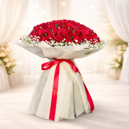 100 red roses bouquet wrapped in white paper with red ribbon bow